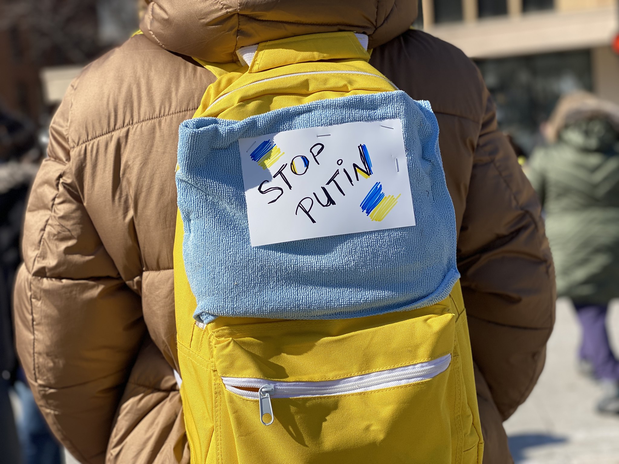 A person wears a backpack with the words 