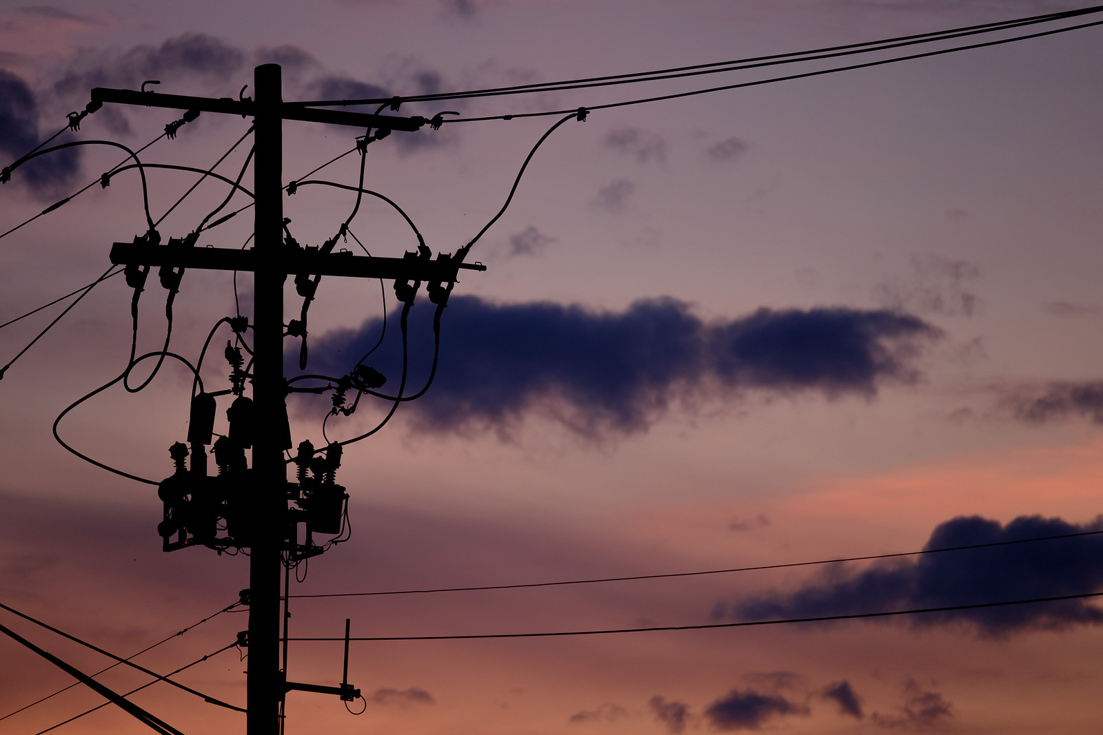 Silhouette of a powerline during a purple-pink sunset.