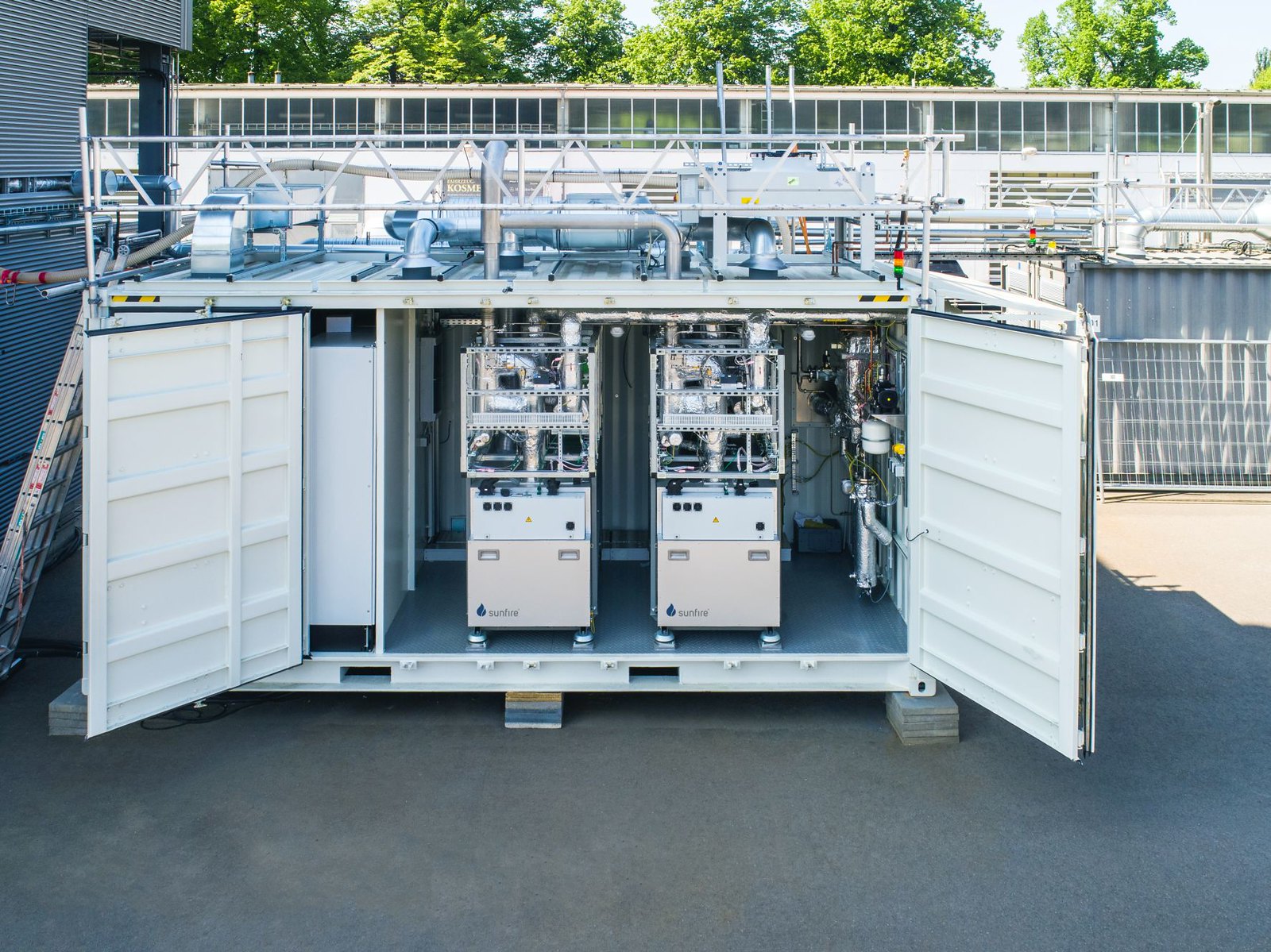 A white crate with open doors revealing hydrogen electrolyzer technology