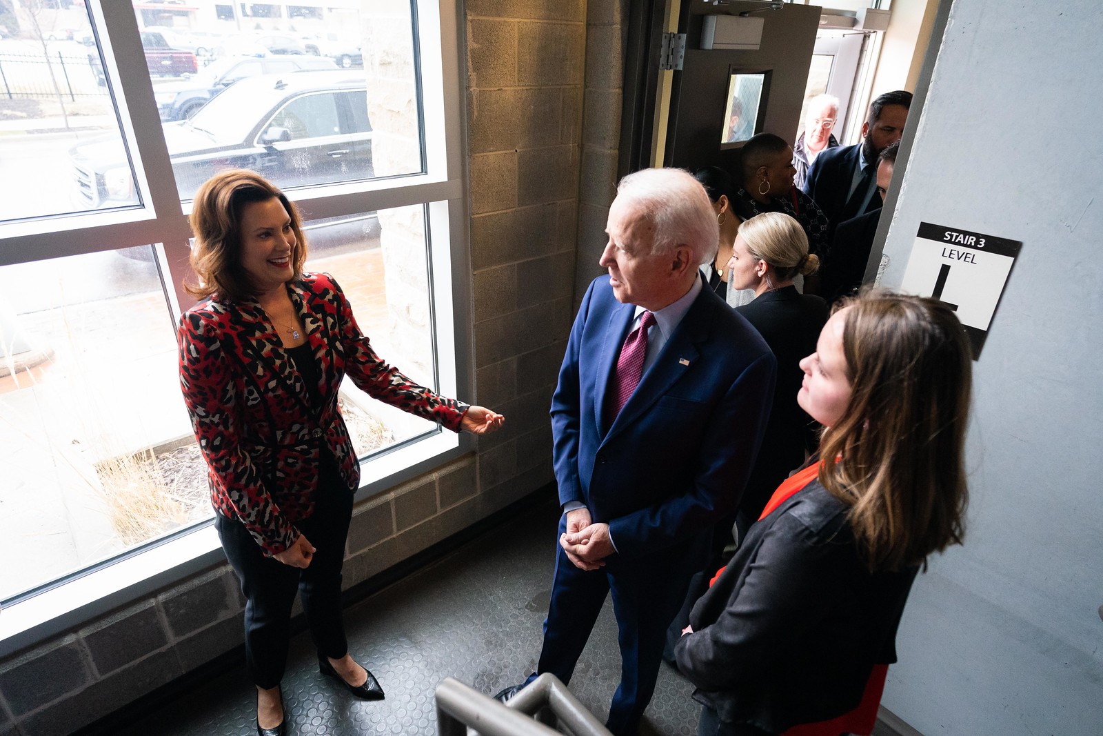 High angle shot of Governor Gretchen Whitmer meeting with President Biden. They are standing indoors and near a large window.