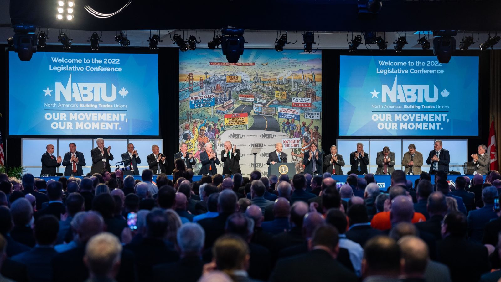 Wide shot of a large crowd listening to Biden deliver remarks at a NABTU conference.