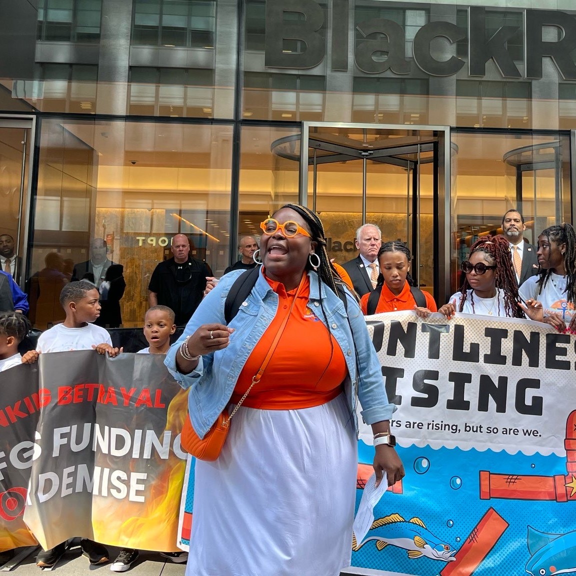 Roishetta leading a climate protest in front of a BlackRock building.