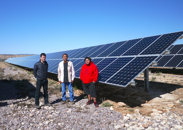 Regional Administrator Jared Blumenfeld, Tribal Council Member and Environmental Director Tommy Siyuja, Sr., and Augie Hanna standing in front of a solar array on Havasupai land.